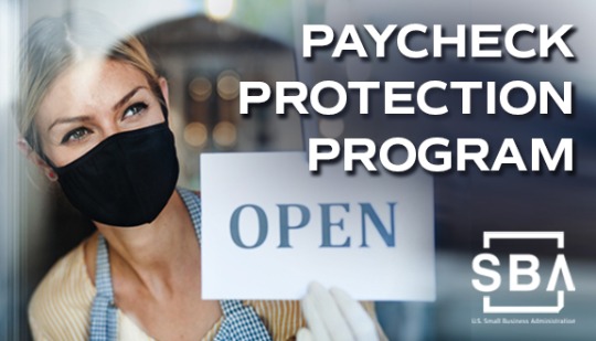 Female business owner in a facemask holding an Open for Business sign with the caption Paycheck Protection Program.